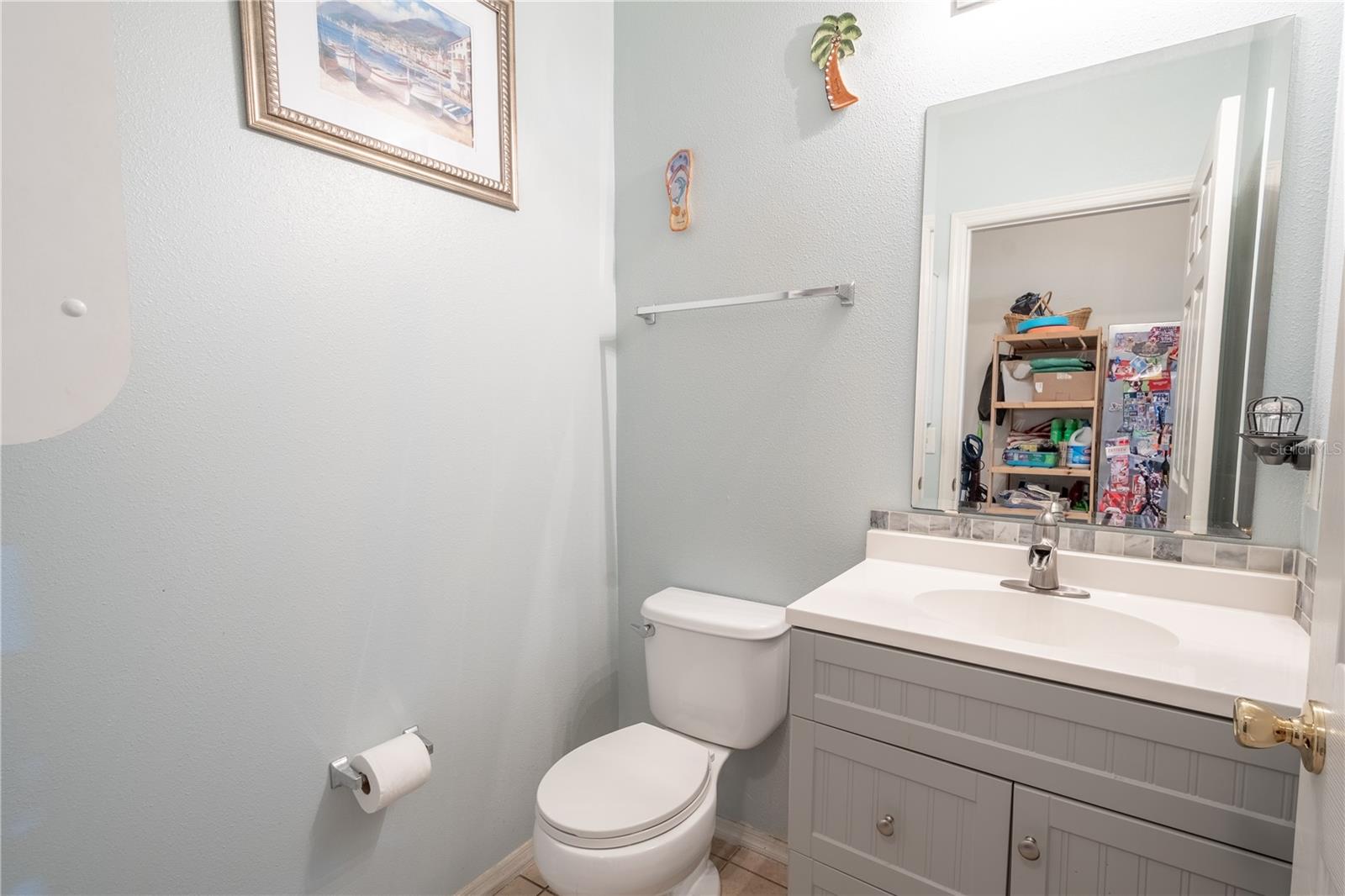 The first floor half bath is conveniently located and features a mirrored vanity with storage.