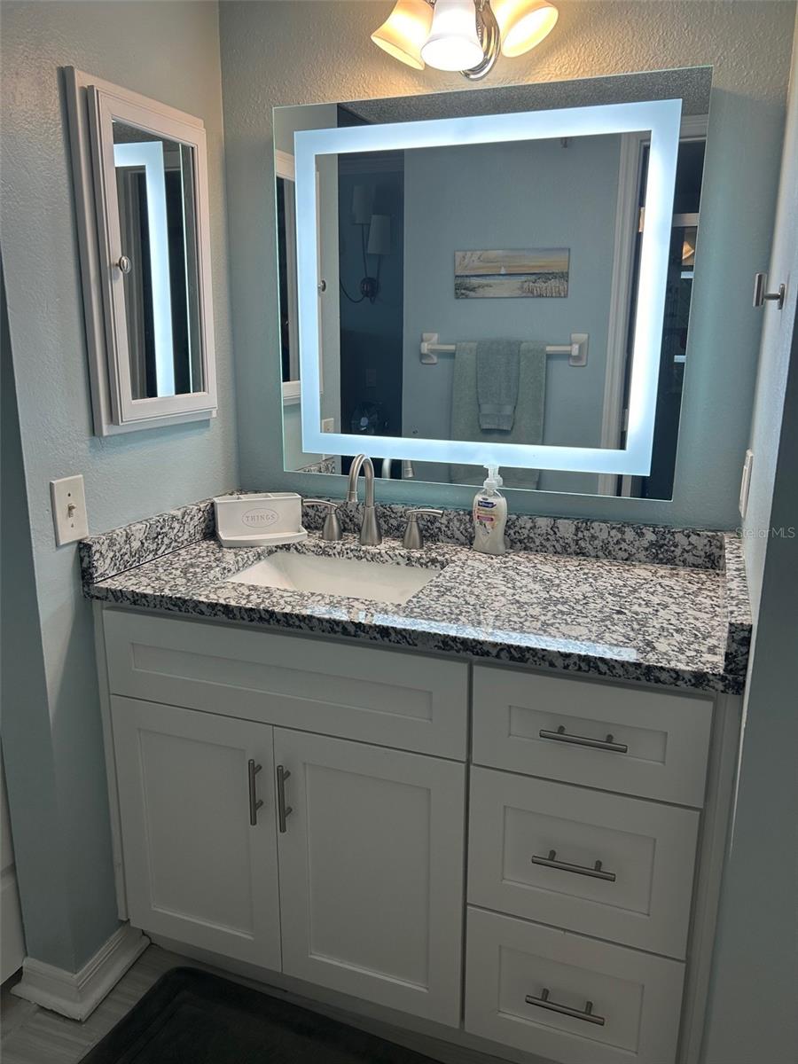 Ultra modern lighted mirror enhances this beautiful vanity in the Master Bath.