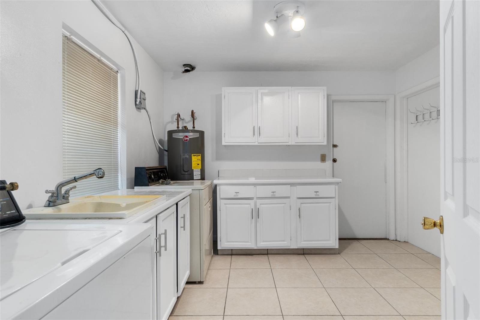 Huge Laundry room with lots of cabinets and counter top space including a sink and washer and dryer