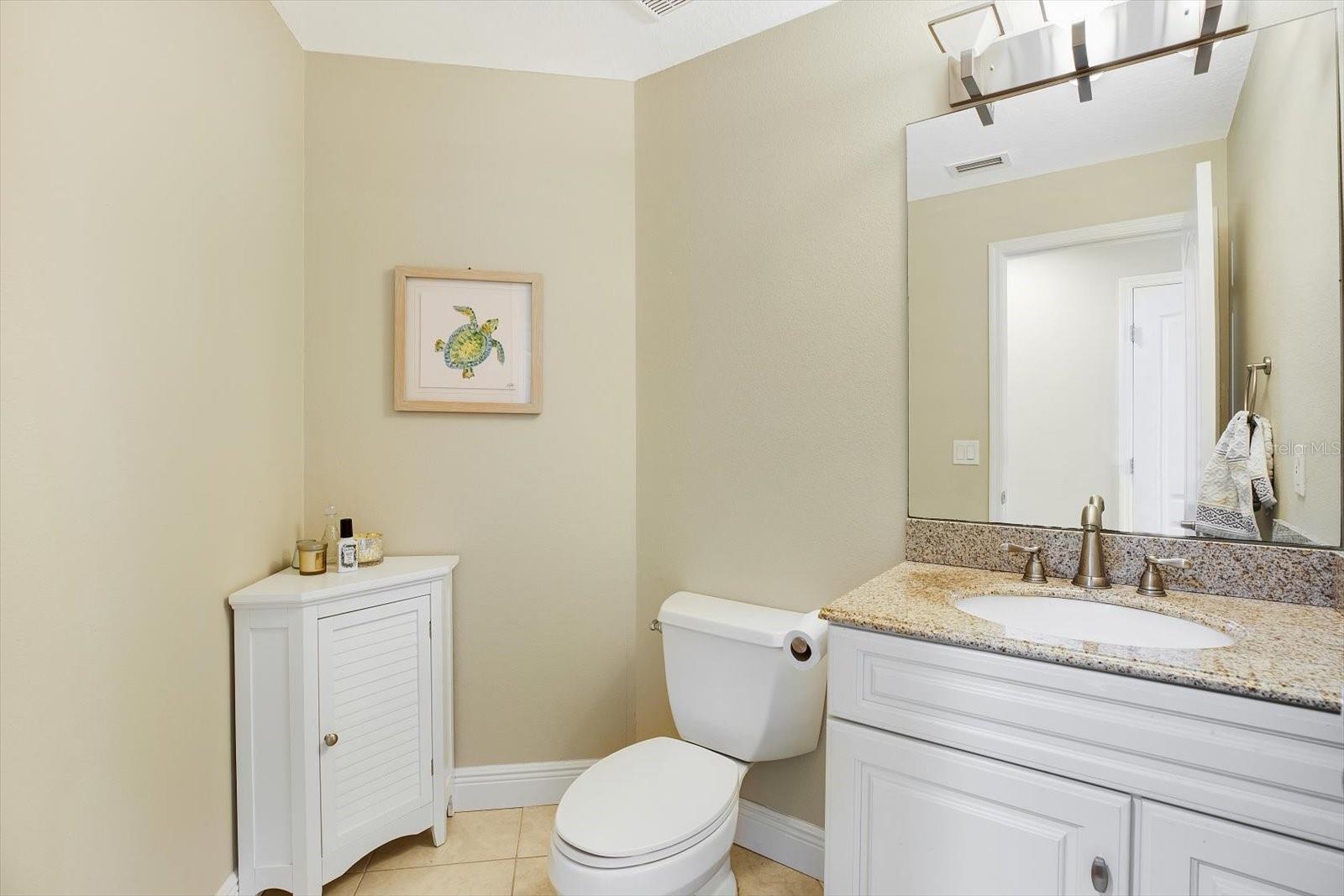 The updated guest half bath is situated in the hall off the living and dinig space