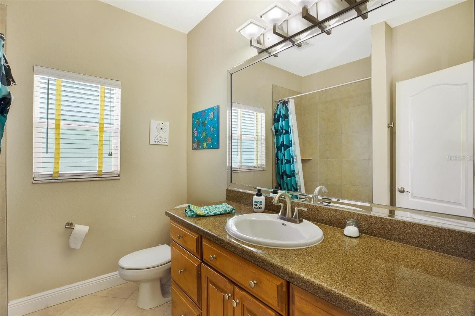 An updated full bath with a tub and shower combo is located between the two bedrooms