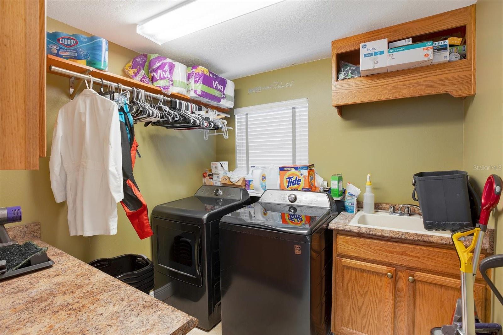 A large laundry room with plenty of storage and counter space for folding and hanging is conveniently located off the kitchen