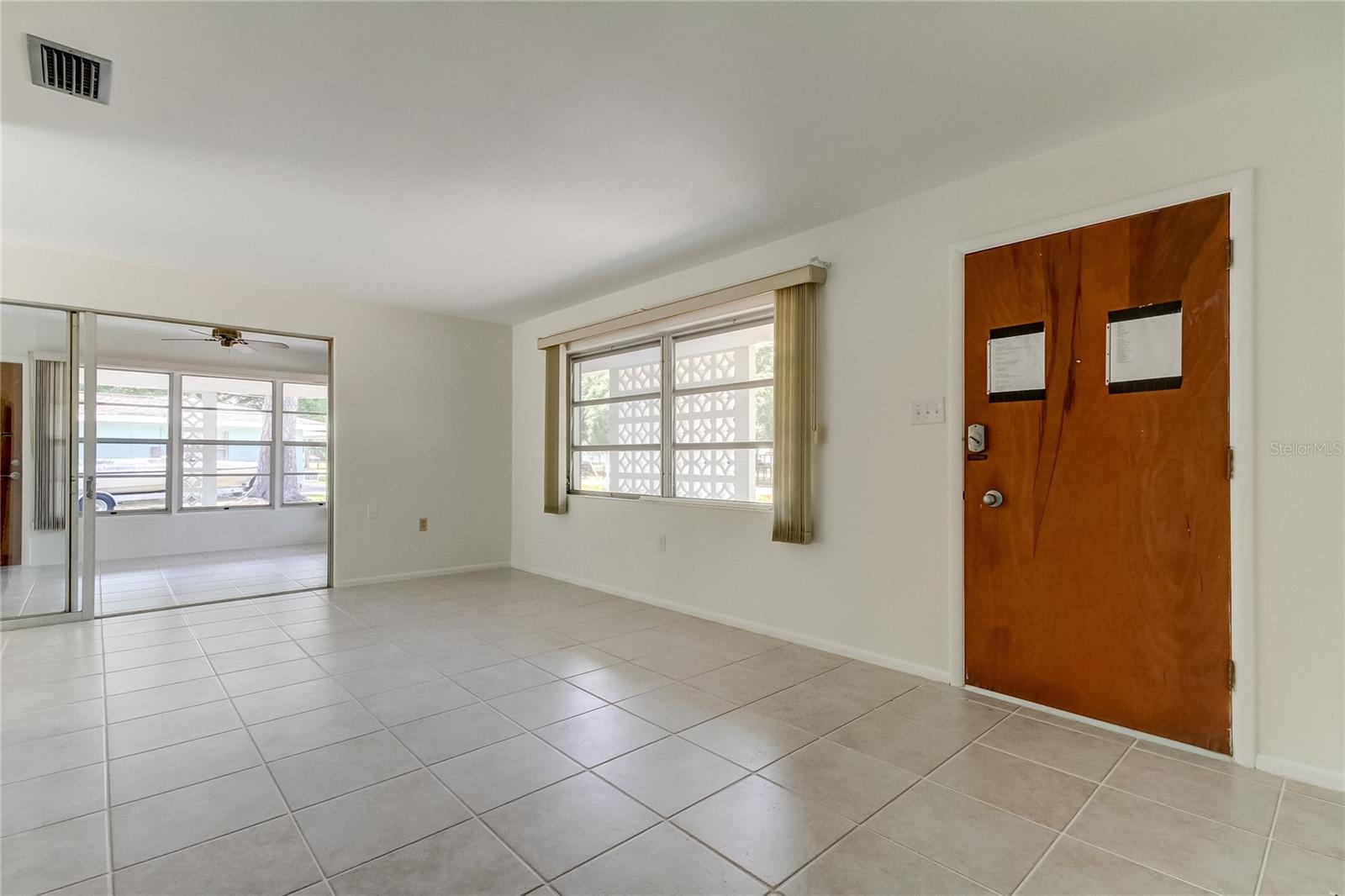 Large front entrance room with expansive windows and views of water.  Ceramic tile floors