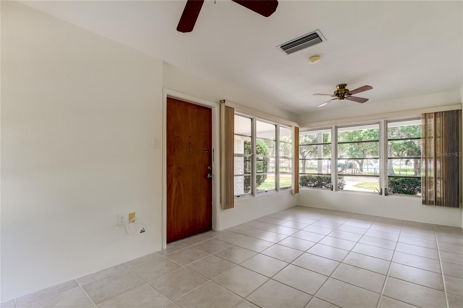 Large front entrance room with expansive windows and views of water.  Ceramic tile floors