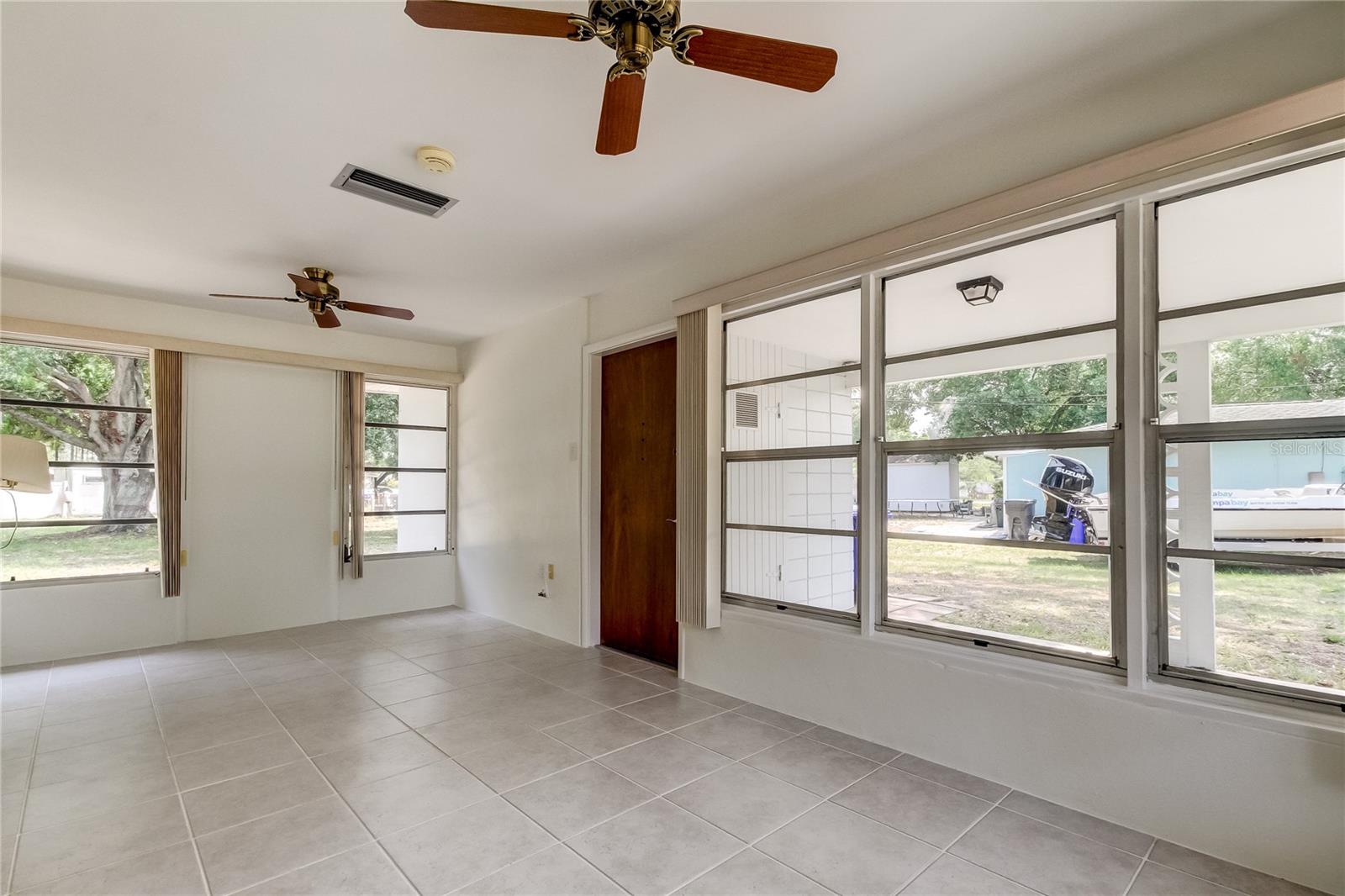 Large front entrance room with expansive windows and views of water.  Ceramic tile floors