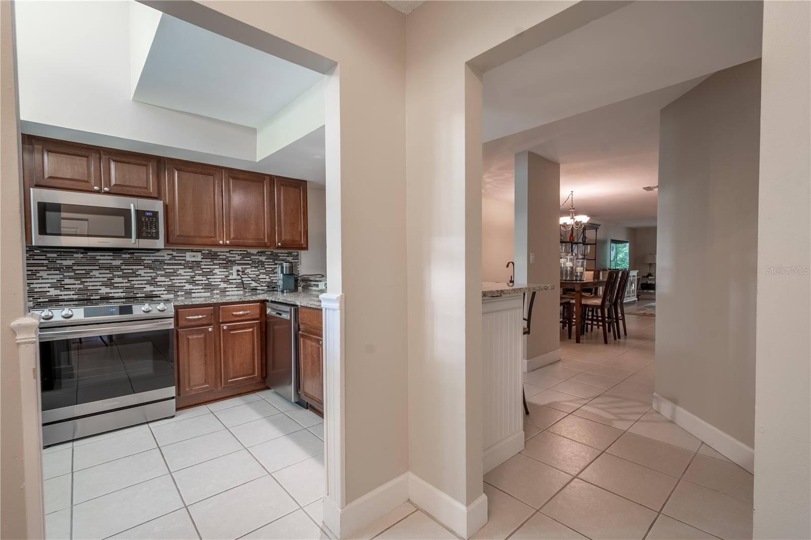 The kitchen features a high ceiling and recessed lighting.