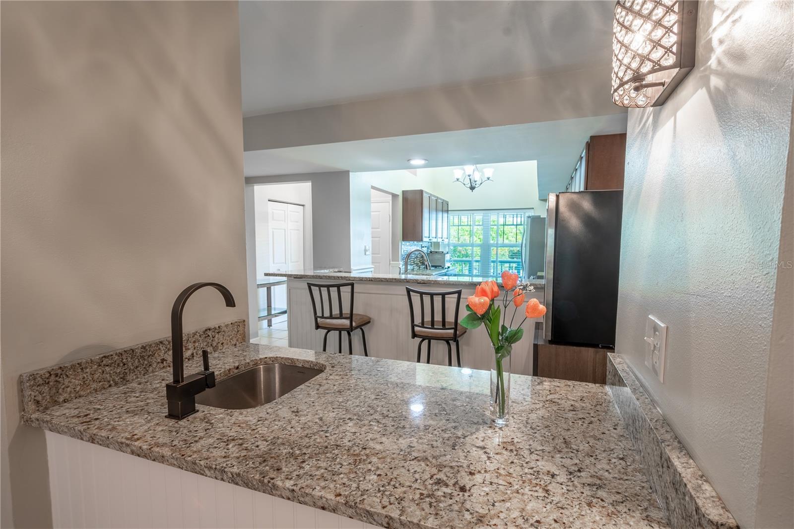 Between the kitchen and dining room is a conveniently located wet bar with sink and granite countertop.