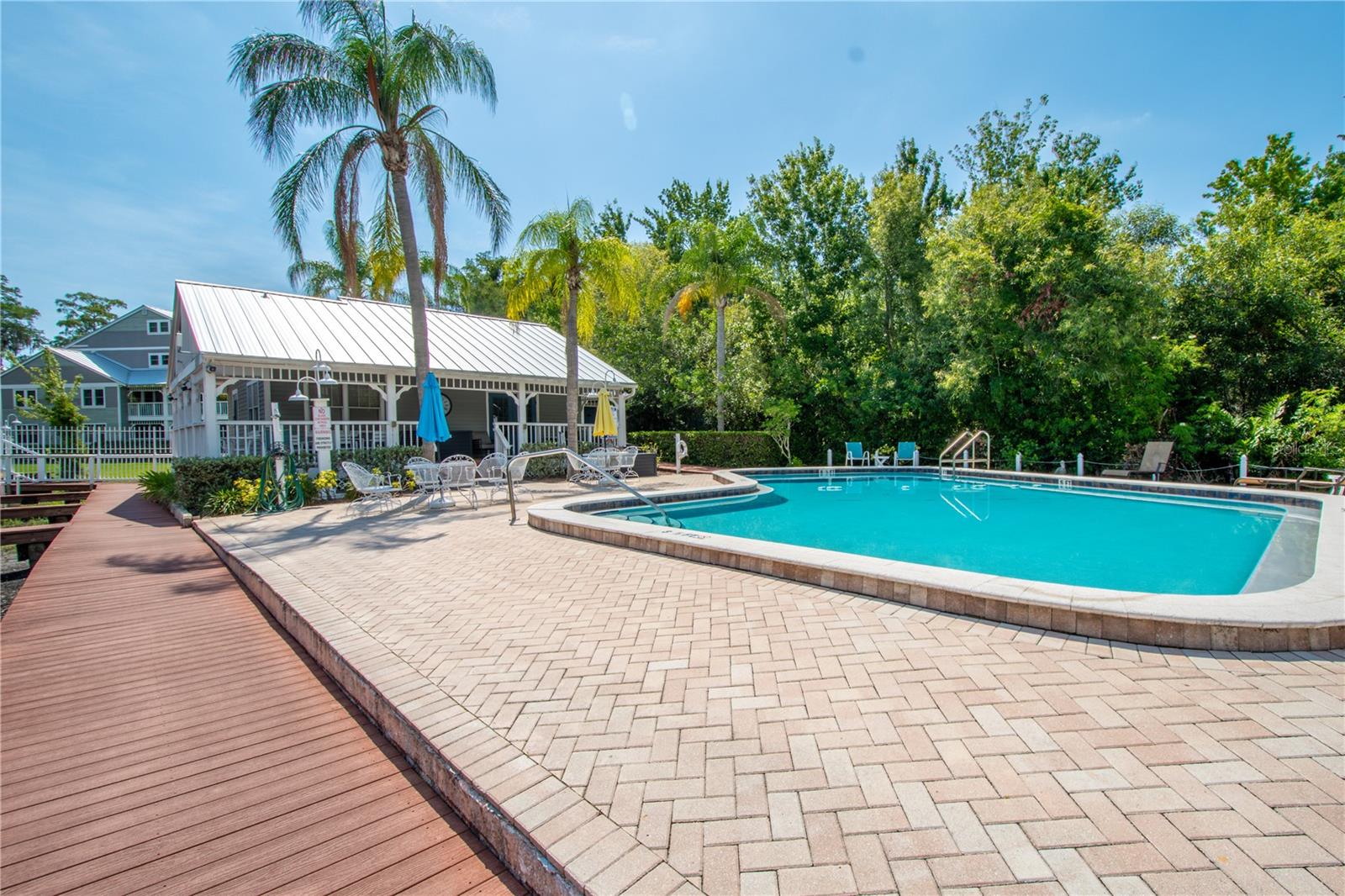 Decking and brick pavers surround the community pool.