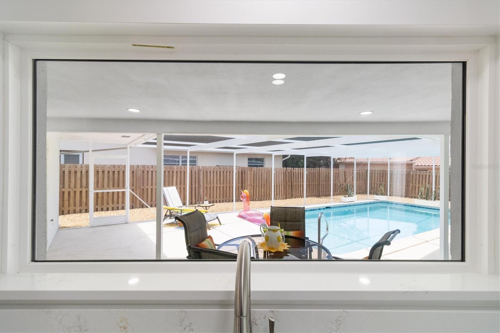 Nice enclosed pool with seating view from the kitchen window