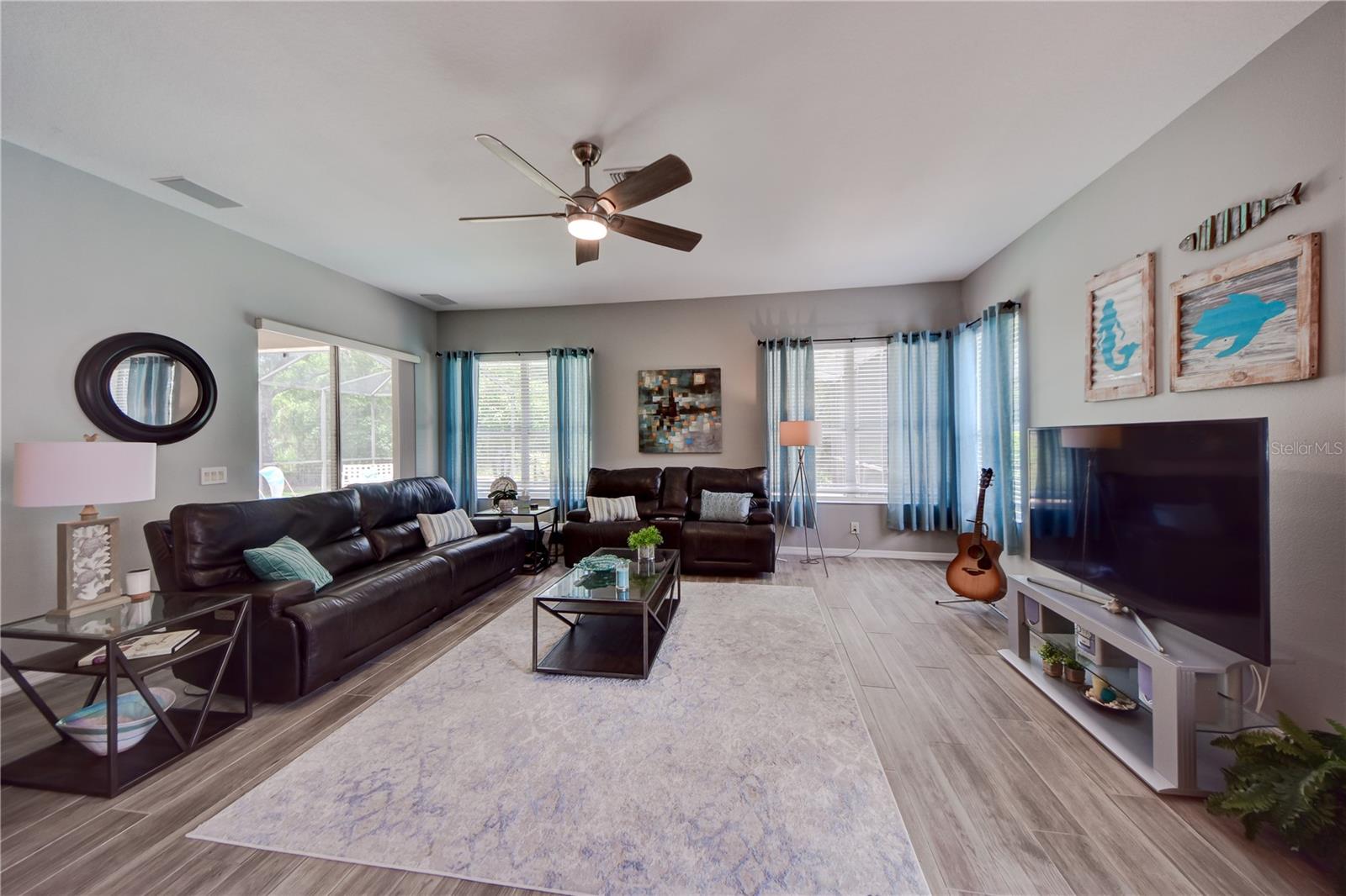 Living Room W/ Sliders Leading To Heated Pool/Lanai and Pool Bathroom