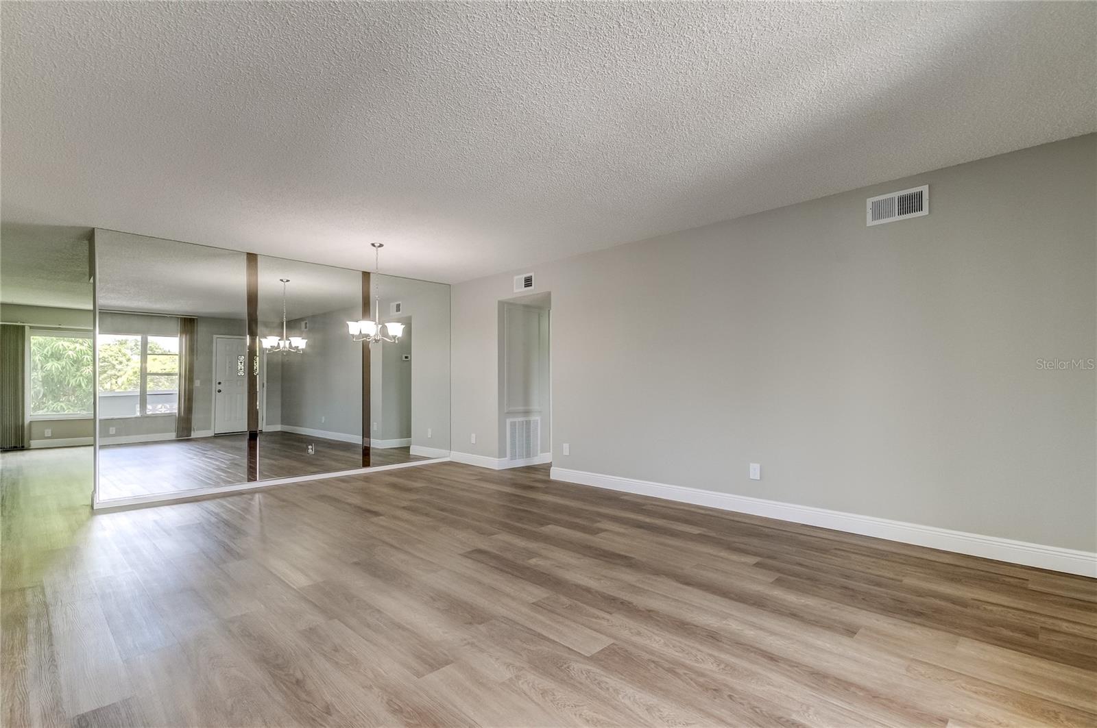 Dining Room/Living Room has mirrors separating Kitchen/Family Room