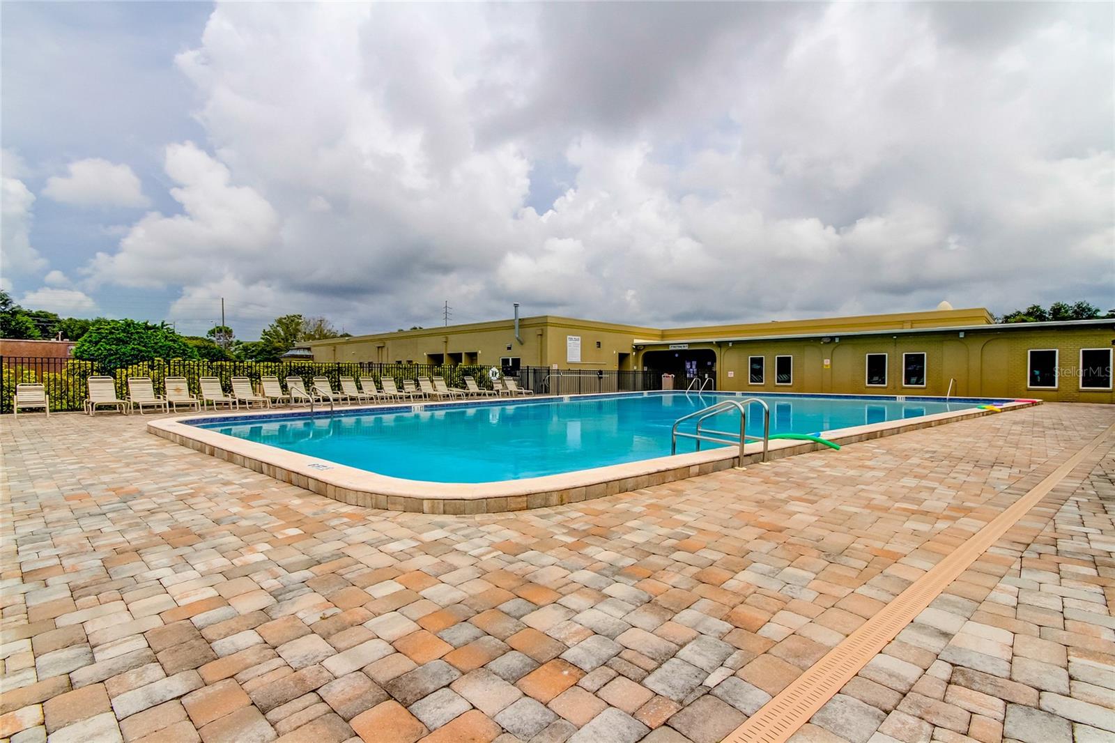 Pavers surround West Side pool, which is close to unit