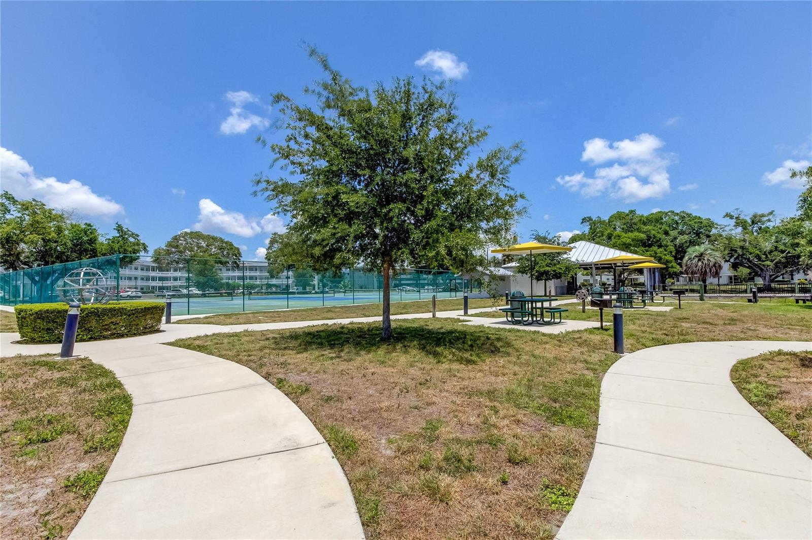 Another view of Tennis Courts and picnic tables with grills