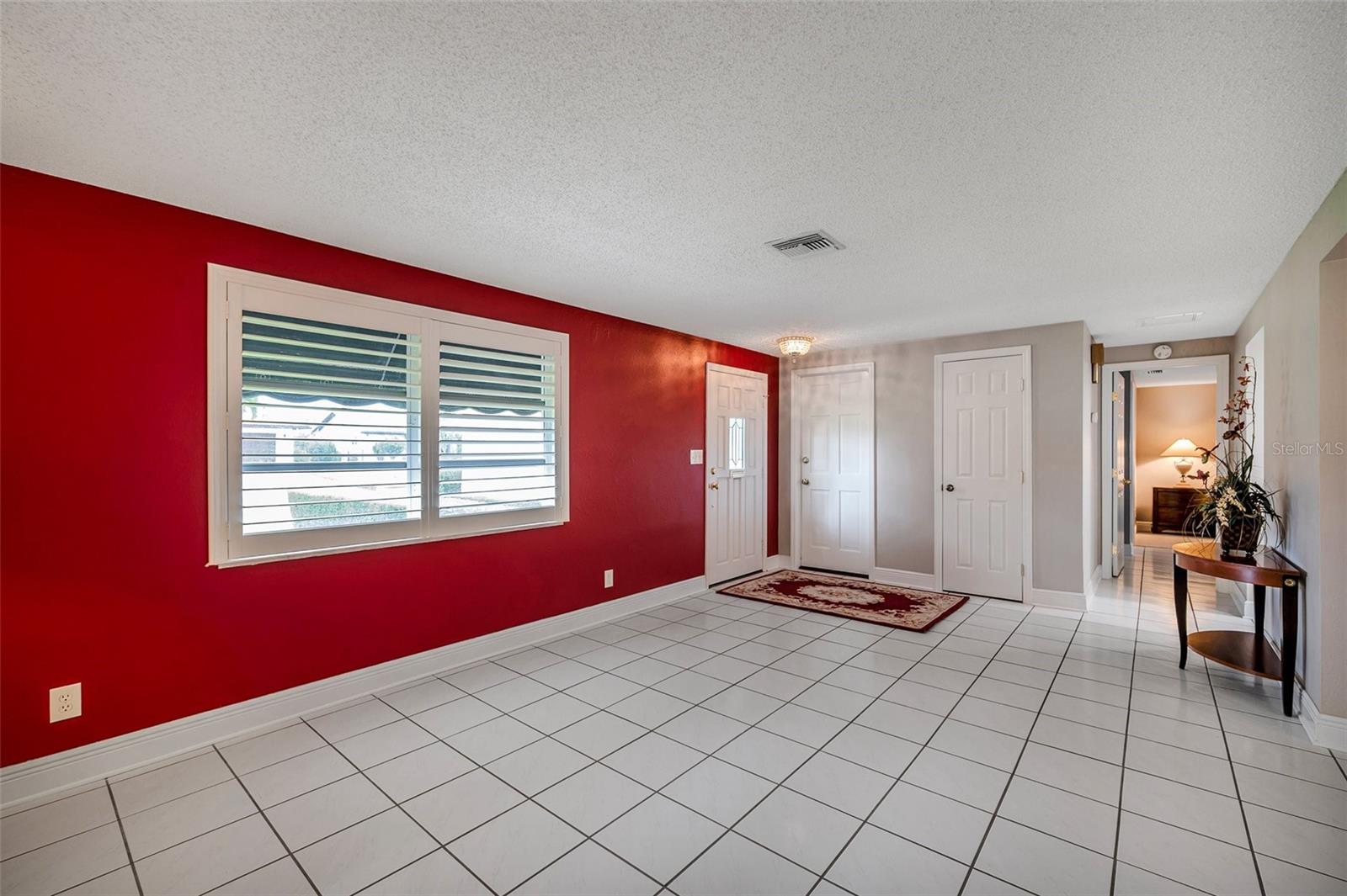 Living room with front door to the left, access garage door in the middle, and coat closet door to the right.