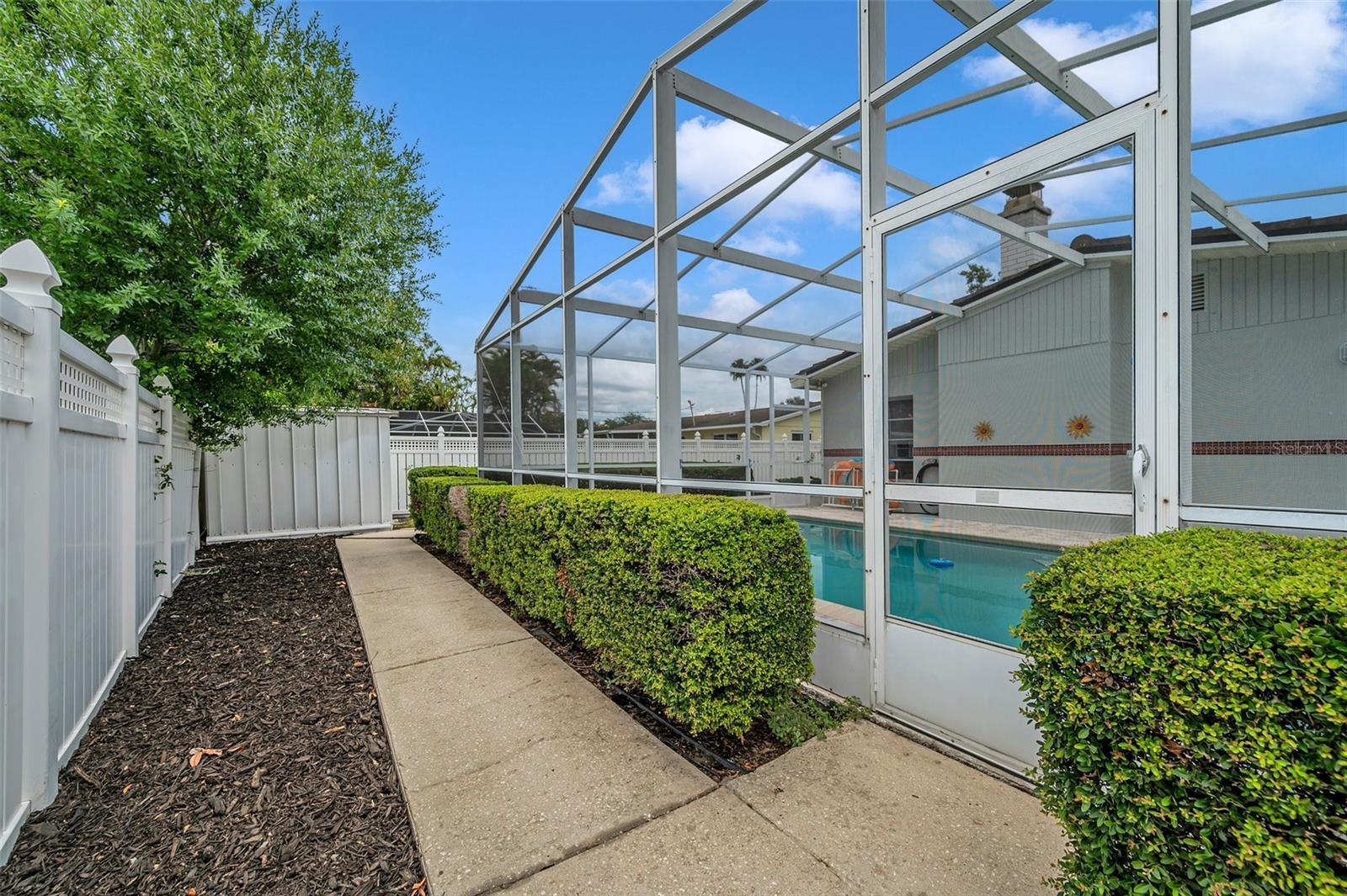 Lot rear with concrete walk to yard shed all enclosed with vinal fence.