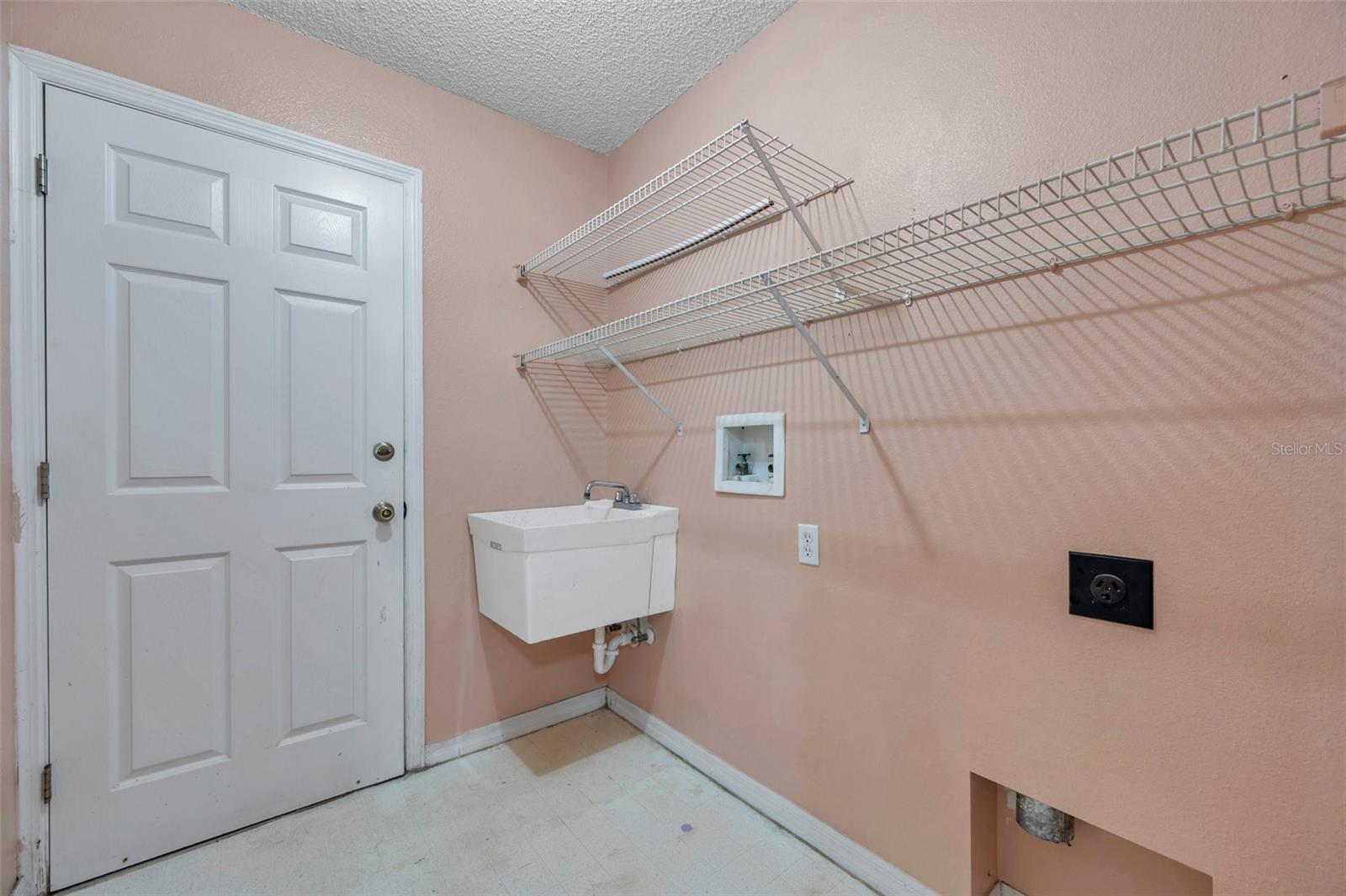 Inside Laundry Room with Built-In Shelving and Sink