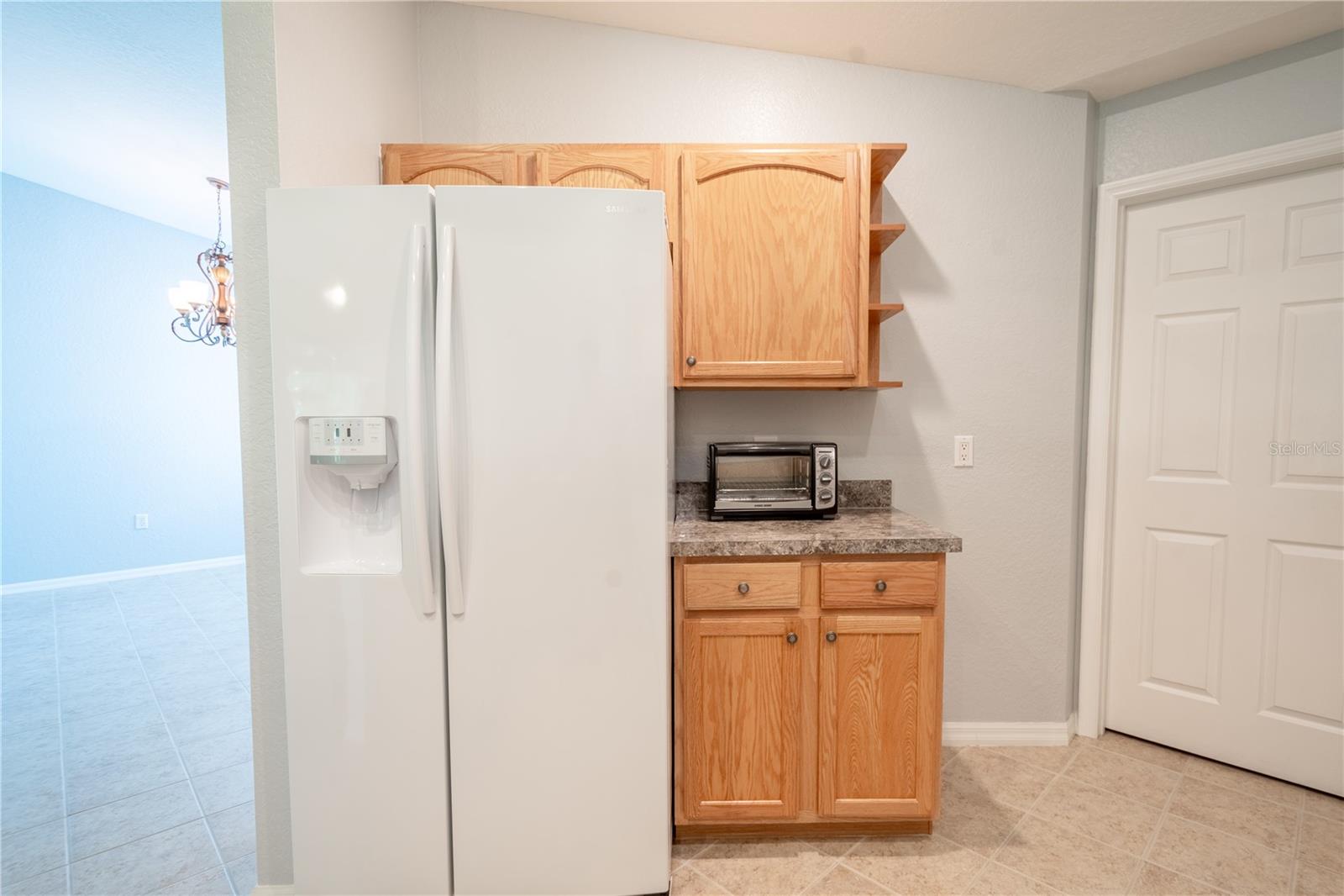 The kitchen features a french door refrigerator with water dispenser and cabinet and counter ideal for your coffee bar.