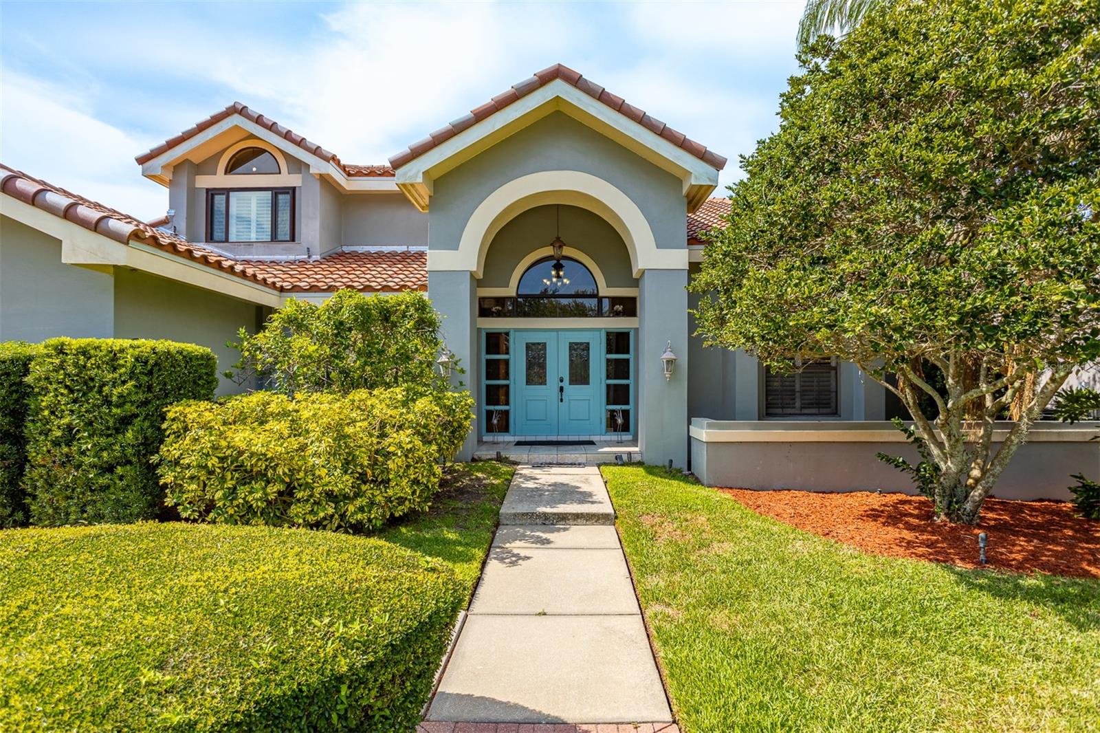 Grand entrance through manicured front lawn