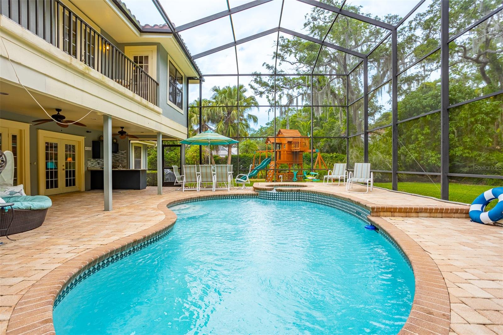 Pool with two story screen enclosure and waterfall hot tub