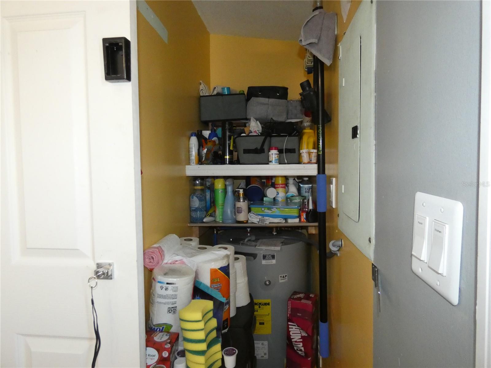 Storage room/pantry/new water heater has a cool decorative barn door that is locked and located next to washer/dryer.