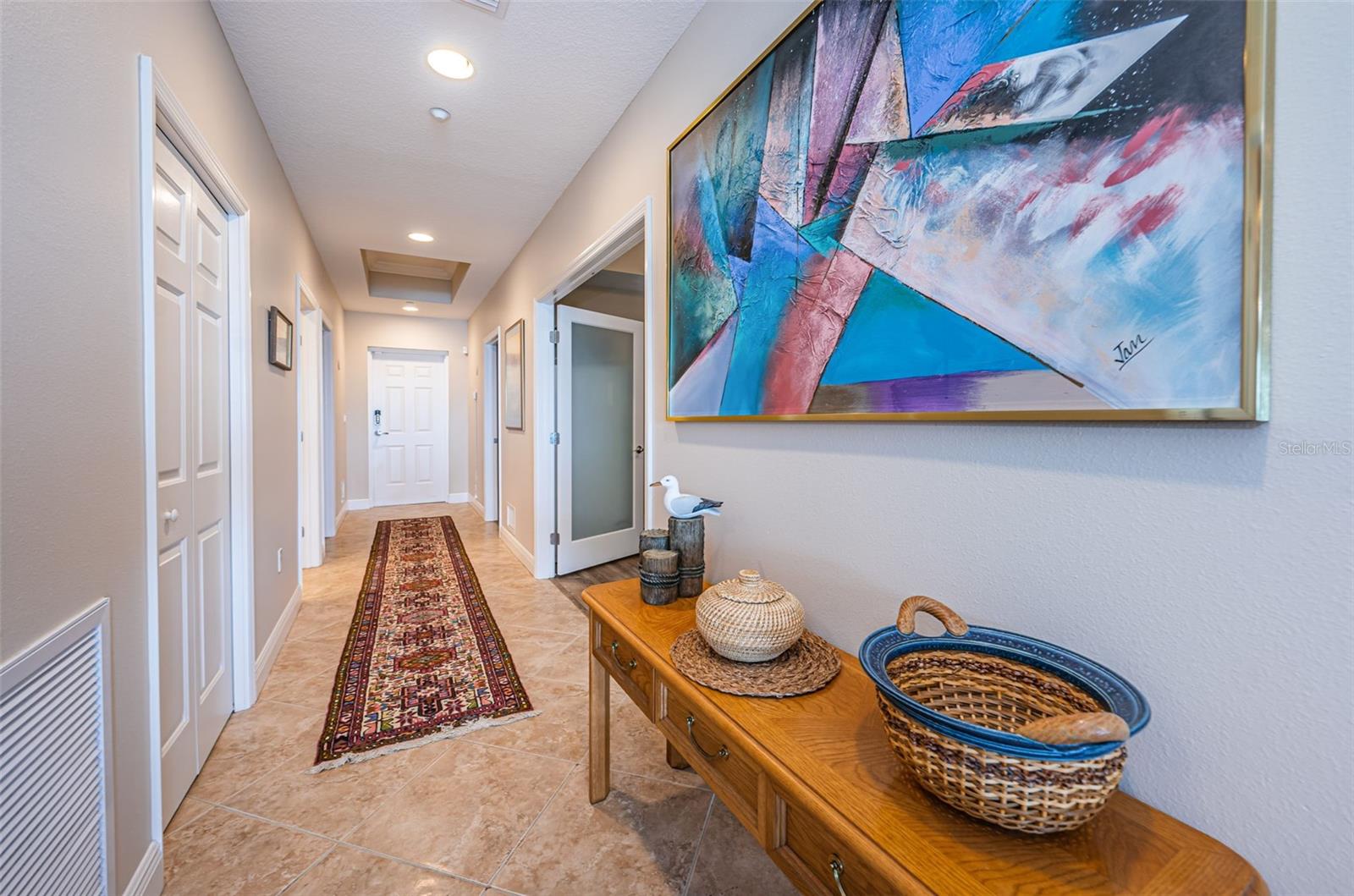 . Hallway Shot Looking Towards  Unit Entrance Door.. Main On- Suite Guest Bedroom Thru Door on Right next to Entrance Door.  Beautiful Tile Thru Foyer and Wet Areas.