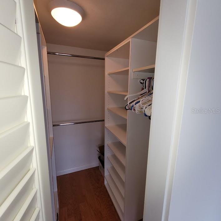 There are 2 closets in the Primary bedroom, this being one with plenty of shelves and bars to hang clothes on.