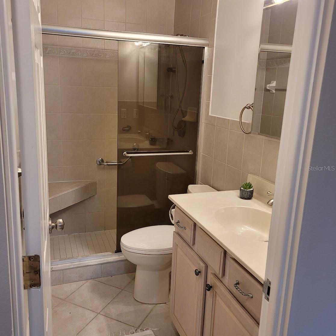 This bathroom has a shower and seat, (no tub).