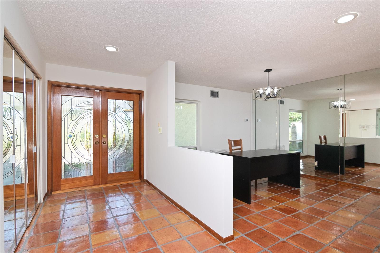 Formal Dining Room with New Paint, New Pendant Light, Hurricane-Rated Window and Tile Floor. View of Entrance and Etched Glass French Doors and Tile Floor.