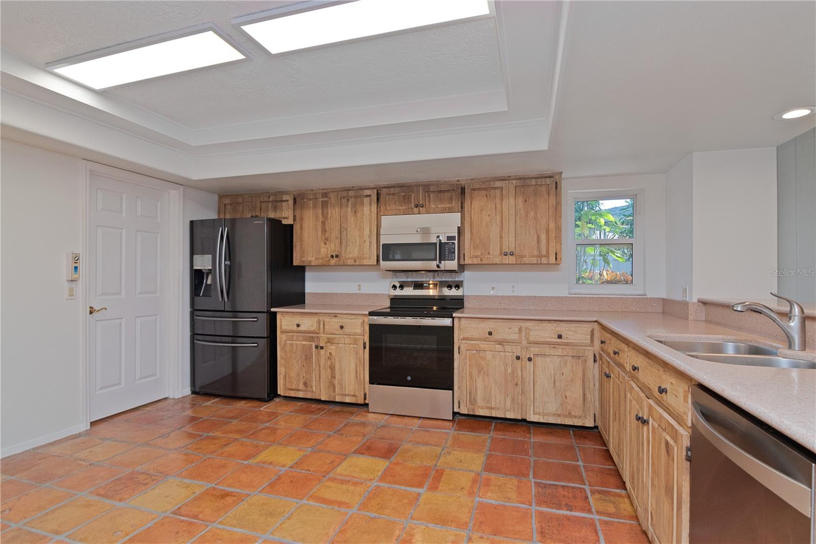 Remodeled Kitchen featuring New Oven/Range, New Paint, Newer Refrigerator, Quartz Countertops, Hurricane-Rated Window and Tile Floor