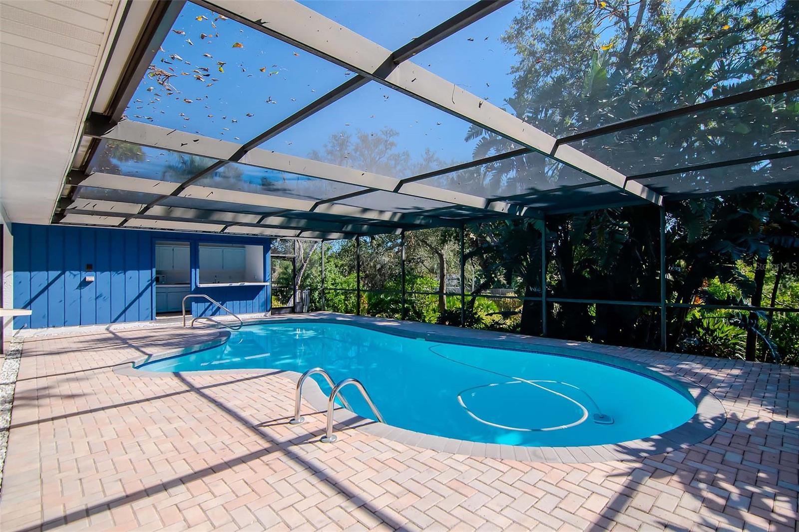 Screened in Pool with Pavers and Lush Landscaping