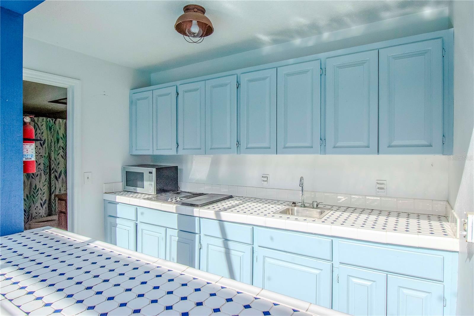 Outdoor Kitchen and Bar with Tile Countertops, Sink and Shelving showing access to Full Outdoor Bathroom