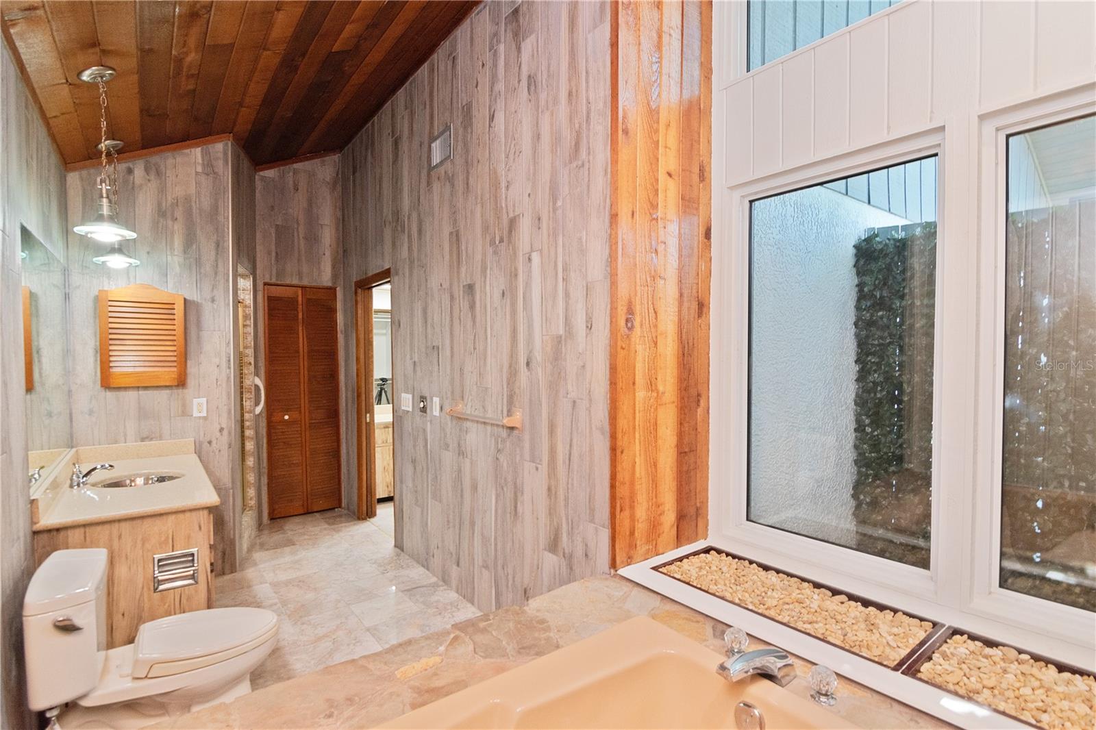 Primary Ensuite Bathroom Garden Tub and View of Outdoor Space with Hurricane-Rated Windows featuring New Paint