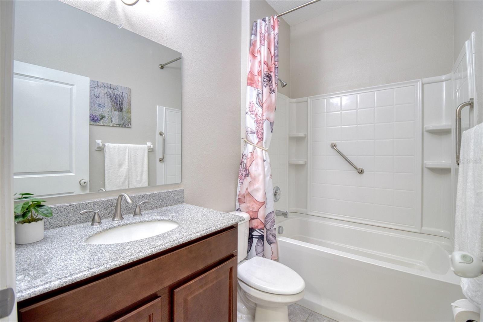 Downstairs bathroom includes a deep bathtub with safetyrailing.