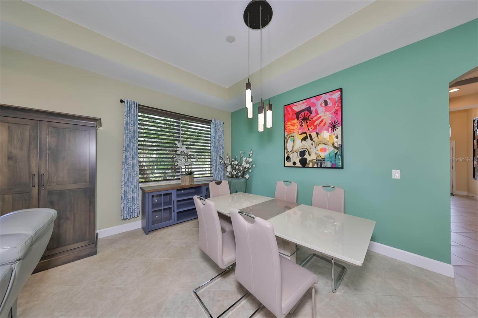 The tile has been placed on the diagonal and contemporary fixtures are throughout the villa.  The custom light fixture and large window accent the space.