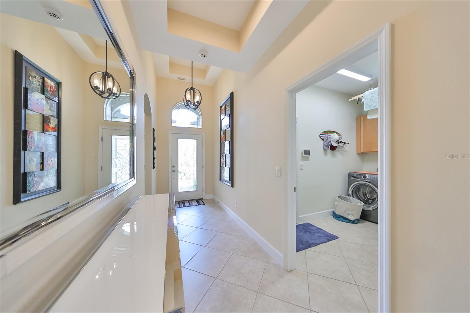 A large, wide foyer welcomes you home with a hurricane impact glass front door and overhead transom allowing Florida sunshine in.