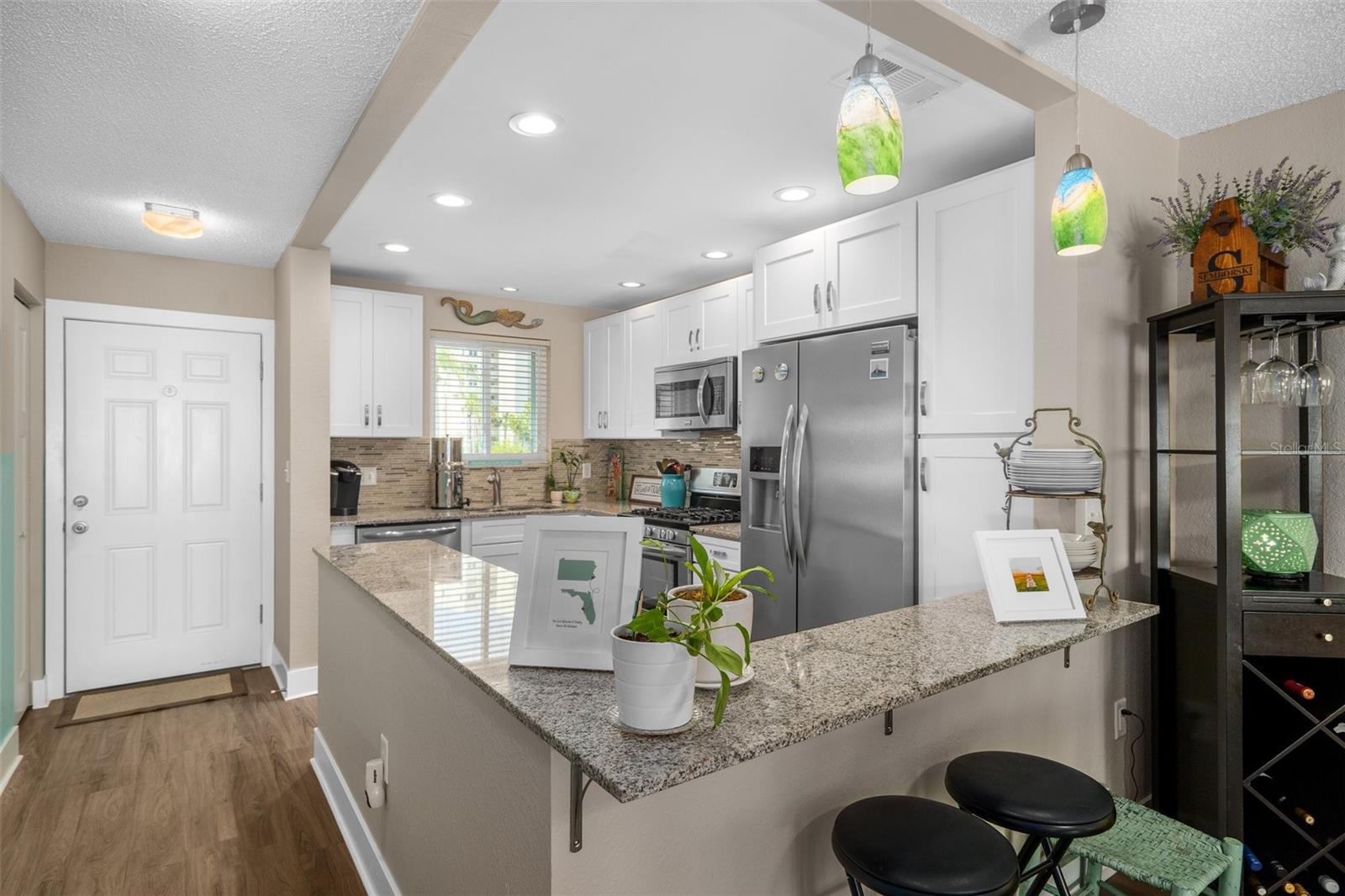 The updated kitchen is a dream with gorgeous granite countertops, white custom cabinets, newer stainless appliances and a great gas stove and a charming kitchen window.  (Gas is included in the HOA fees).