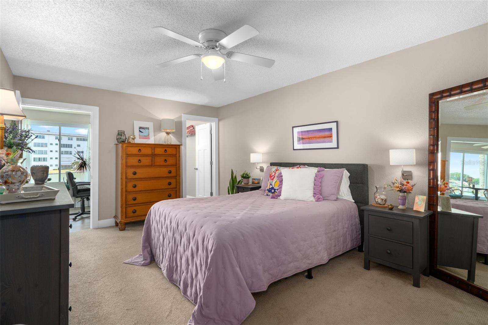 Spacious primary bedroom with large walk-in closet, updated en suite bathroom and doorway into the Florida Room.