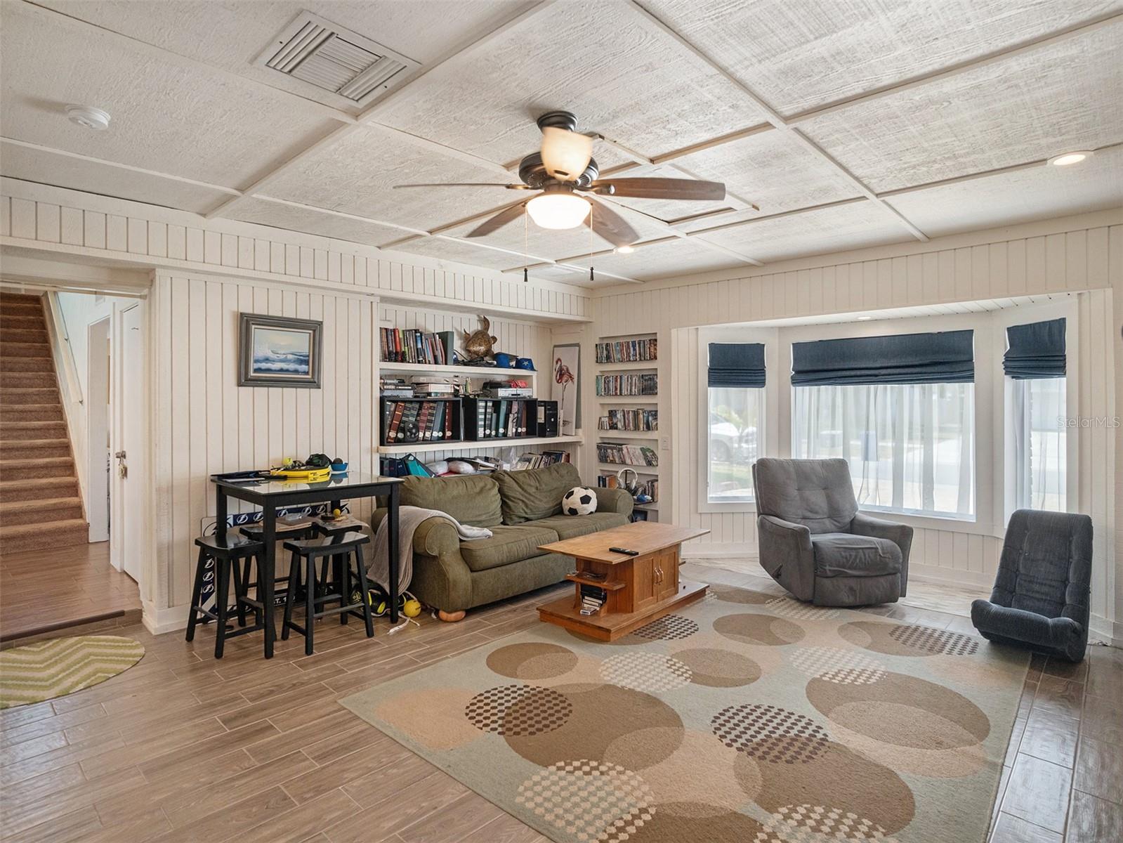 Family room with beamed ceiling, fireplace, and tons of natural light showcasing the pool and canal. with a wet bar keeps the fun going.