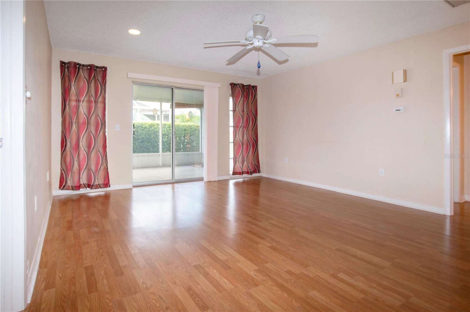 Family room with laminate flooring and sliders to screen lanai