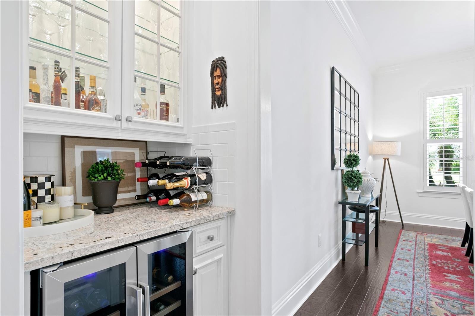 The bar area with wine fridge connects the formal dining room and living room