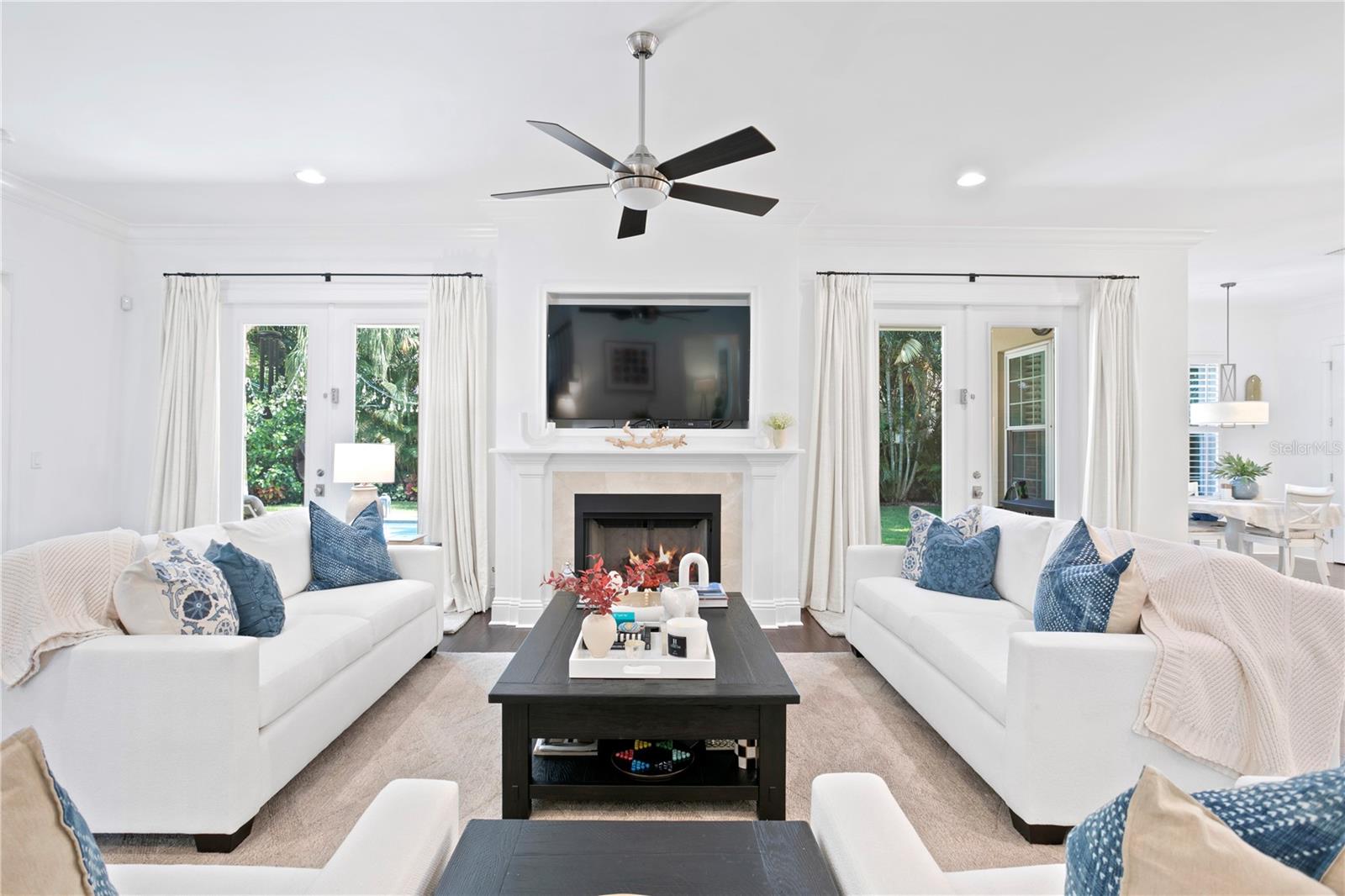 The inviting living room with working fireplace and access to the backyard and pool