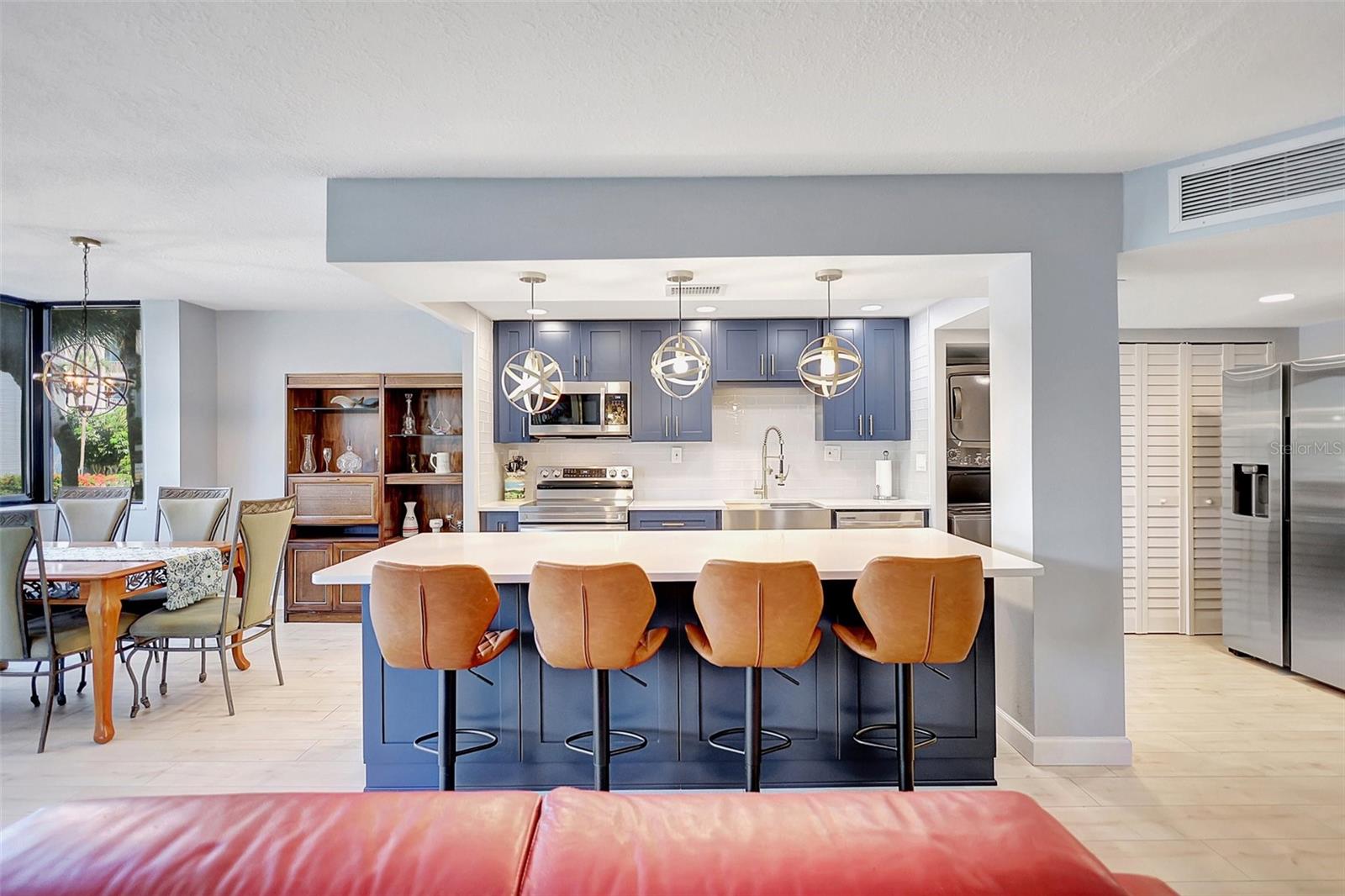 The kitchen blends functionality with modern sophistication. Adorned with a sleek countertop island table, perfect for casual dining or culinary creations, and complemented by ample cabinet space for storage, this kitchen is a chef's delight.