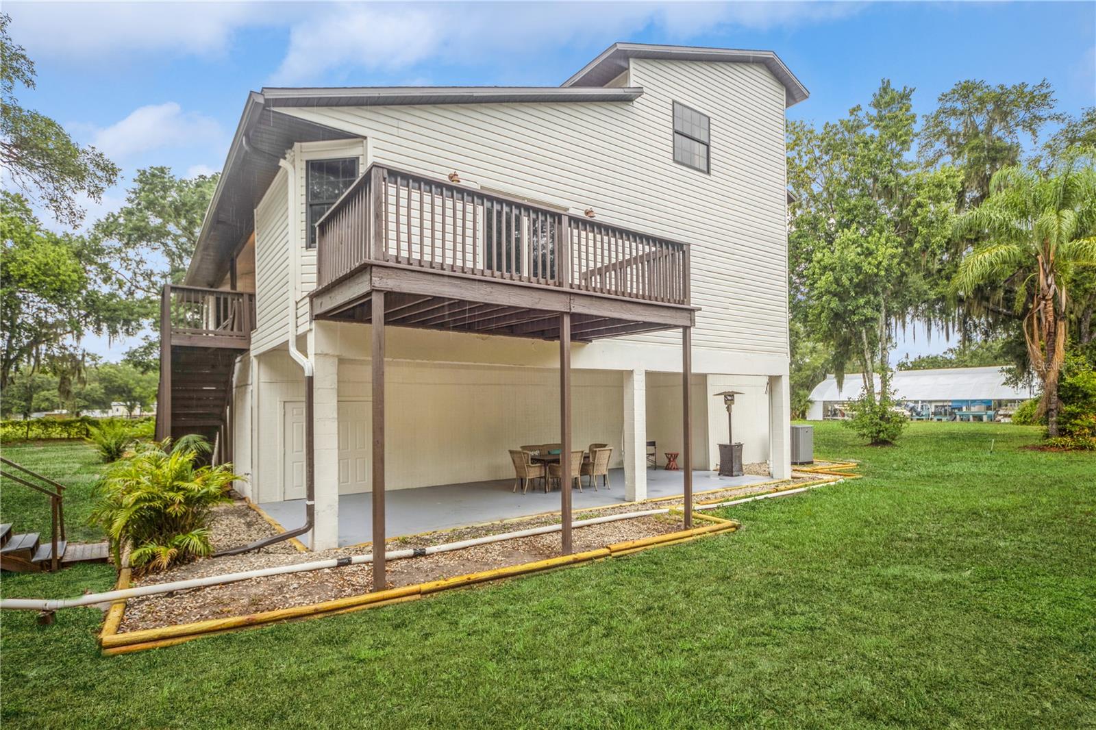 Side of the home with primary balcony and side porch