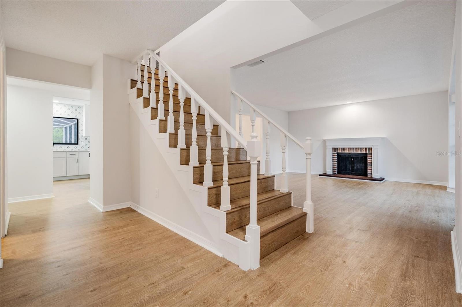 Entry looking into living room on the right, kitchen straight ahead, primary bedroom to the left