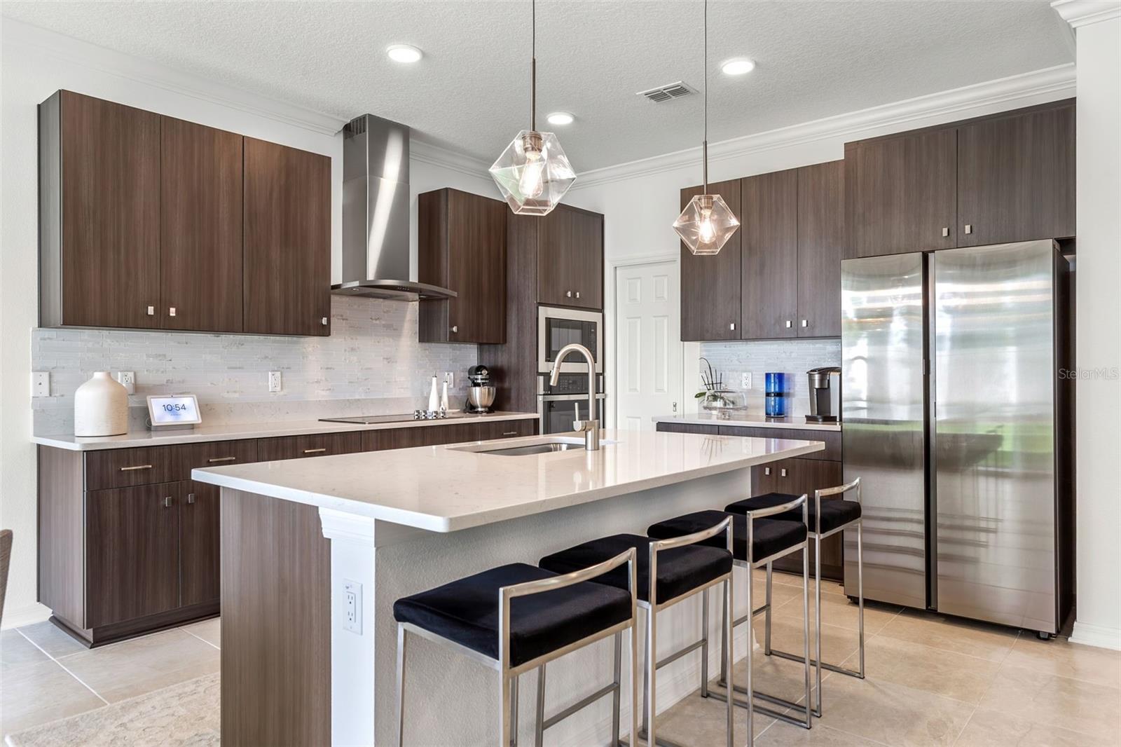 Tall cabinetry, stainless steel appliances, hood, and cooktop with brand new backsplash just installed!