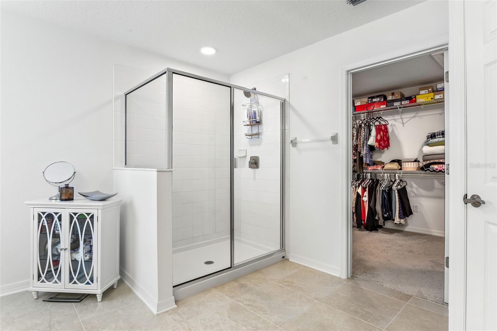 Standing shower in primary bath leads to walk in closet.