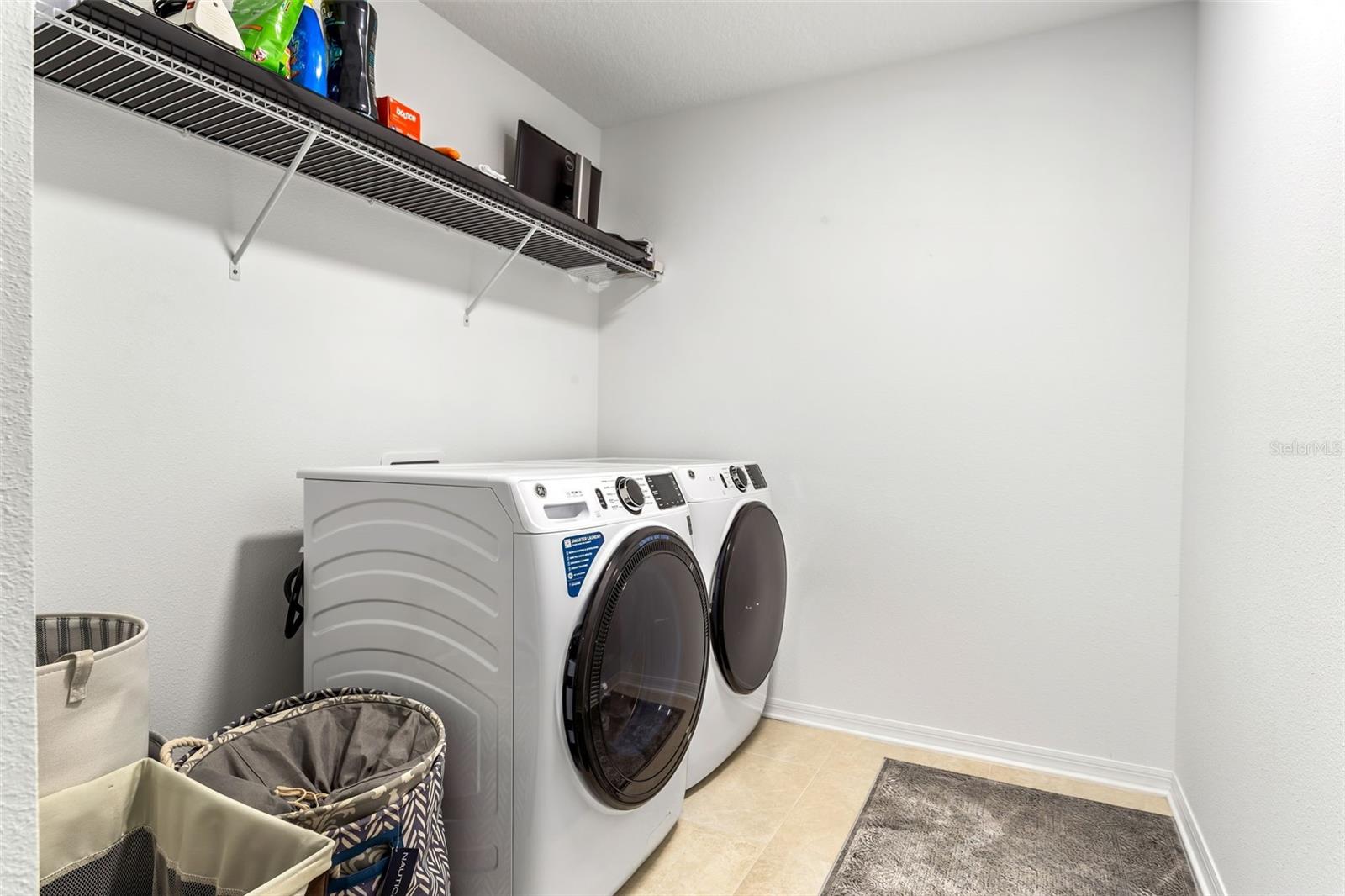 Laundry room is on the second floor with shelving and laundry prep area.