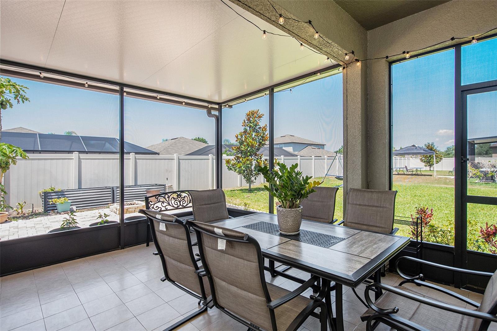 Partially fenced backyard with an extended covered lanai, a perfect place to unwind.