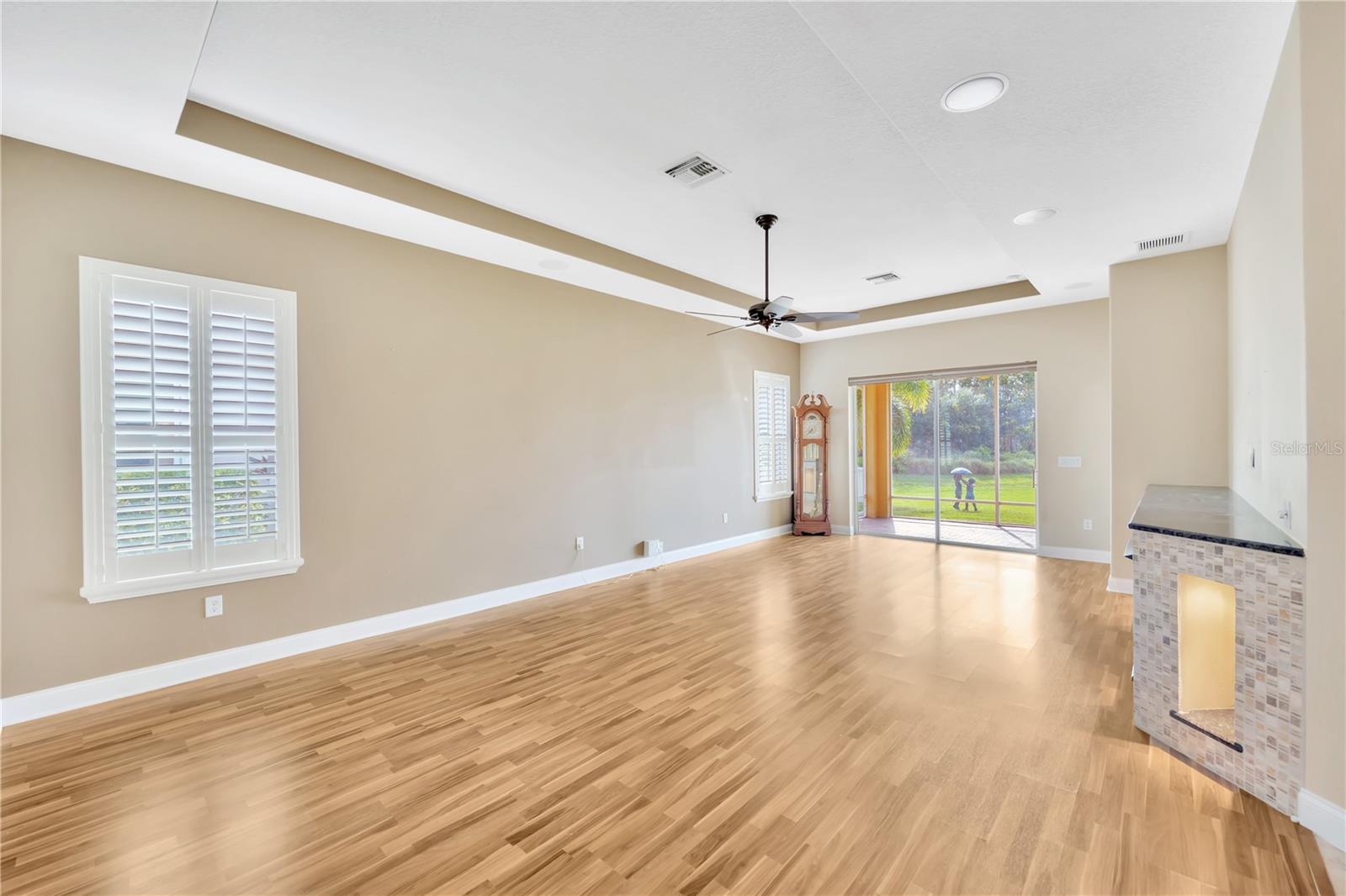 Living opens to the screened patio. Plantation shutters