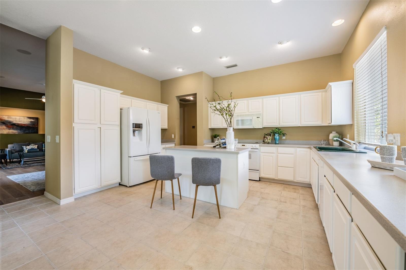 Spacious and open kitchen, tile flooring and corian countertops